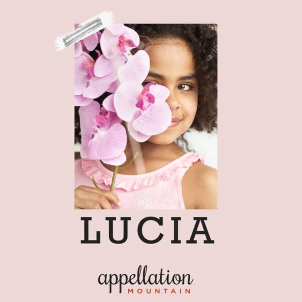 girl child with dark hair wearing pink dress and holding pink flowers in front of half of her face; baby name Lucia