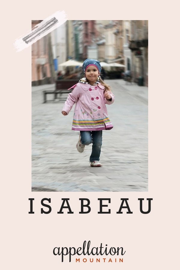 toddler girl wearing pink coat, blue jeans, and head scarf running on medieval stone street; baby name Isabeau