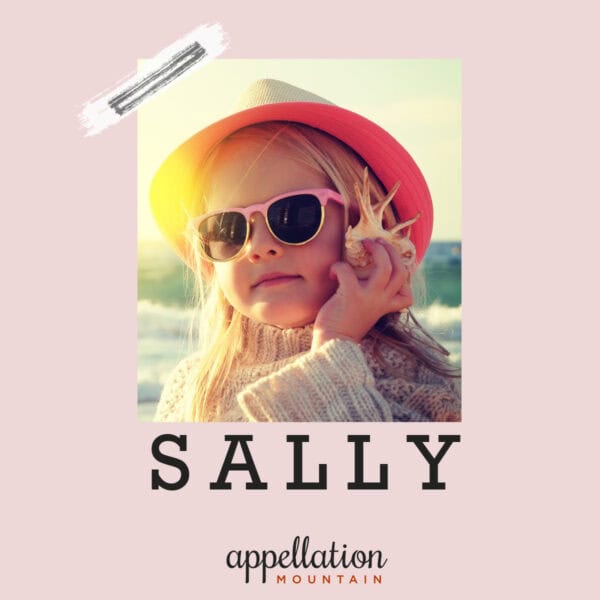 blonde girl wearing sunglasses, sweater, and pink hat on sunny beach; baby name Sally