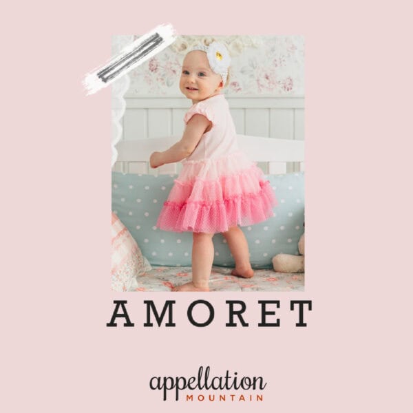 toddler in dress with pink skirt and floral headband; text reads "Amoret"