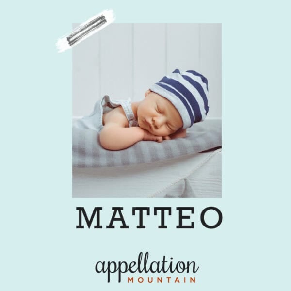 sleeping baby wearing knit blue striped cap wrapped in gray blanket; baby name Matteo