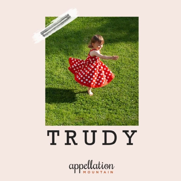 girl twirling in red polka dot dress in middle of field "name of the day Trudy"