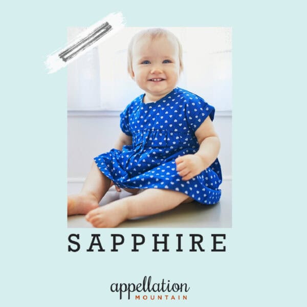 baby girl with blonde hair in blue and white polka dot dress; baby name Sapphire