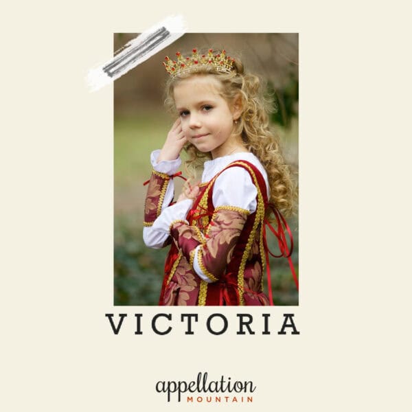 girl with long blonde curly hair wearing medieval-style burgundy and gold gown plus small golden crown; baby name Victoria