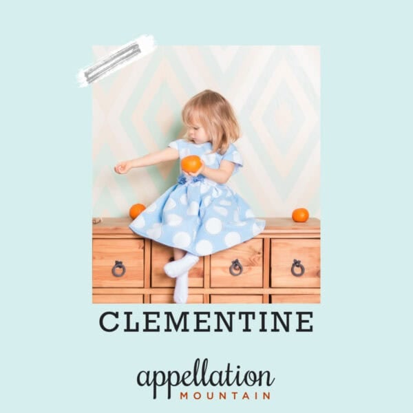 girl child with short blonde hair wearing blue dress holding clementine; baby name Clementine