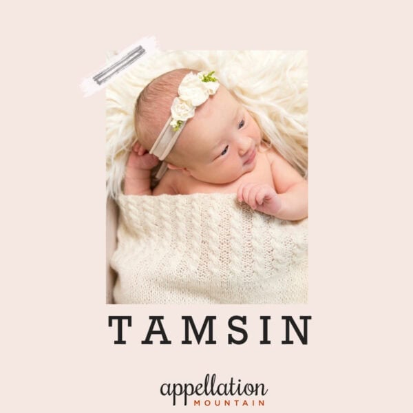 baby girl wearing floral headband under ivory knit blanket; baby name Tamsin