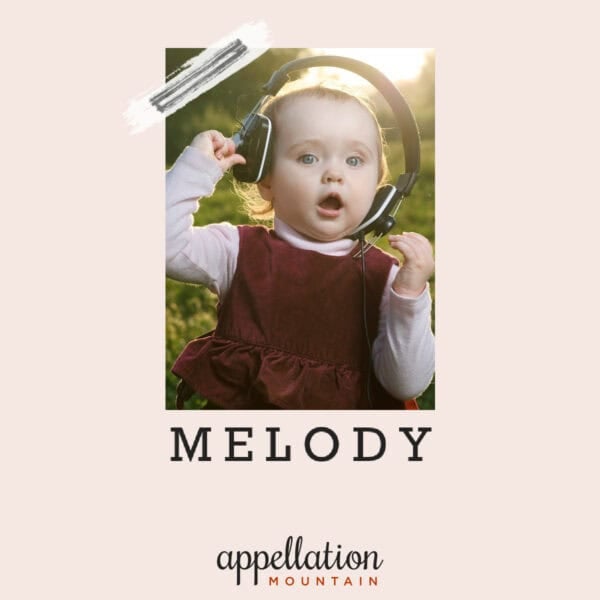 baby girl with light blonde hair wearing burgundy jumper over light pink top wearing headphones; baby name Melody