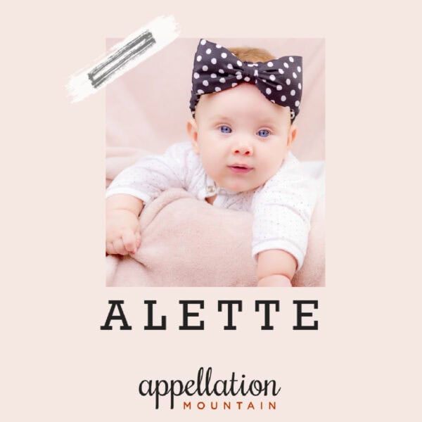 baby girl with navy and white polka dot bow around her head and white top; text reads Alette