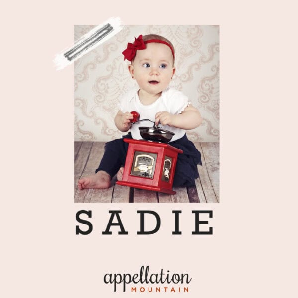 baby girl with red headband holding vintage device; text reads "Sadie"