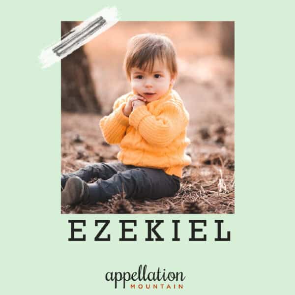 toddler boy with dark hair sitting in forest wearing light orange fleece; Baby Name of the Day Ezekiel