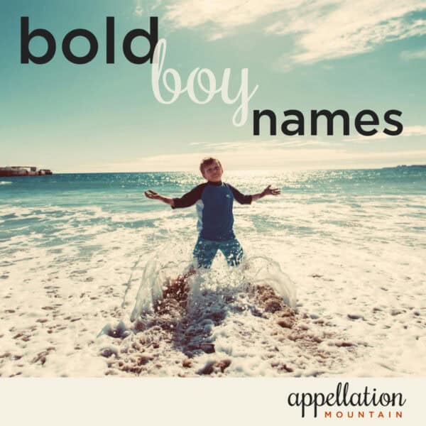 boy child standing in rushing ocean surf; bold boy names like Jax