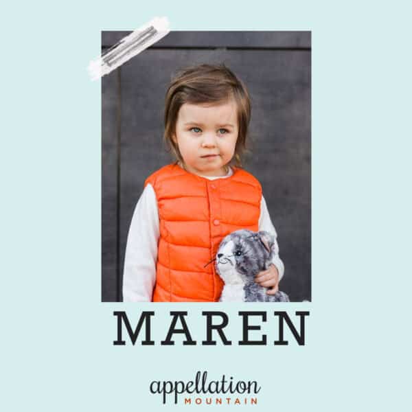 girl child with short brown hair wearing orange vest holding stuffed cat toy; baby name Maren