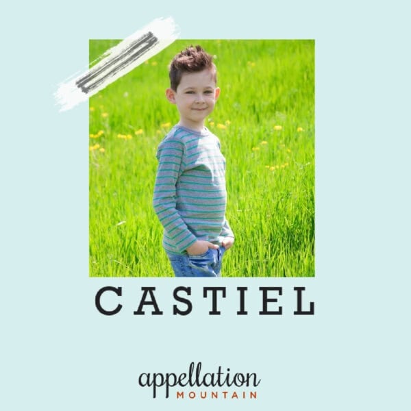 boy with short dark hair wearing a blue long sleeve shirt and jeans standing in field of green grass; baby name Castiel