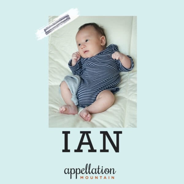 baby boy wearing navy and white stripe onesie on white blanket; baby name Ian