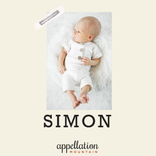 baby boy wearing off-white button-up onesie, lying on his back on white sheet; baby name Simon