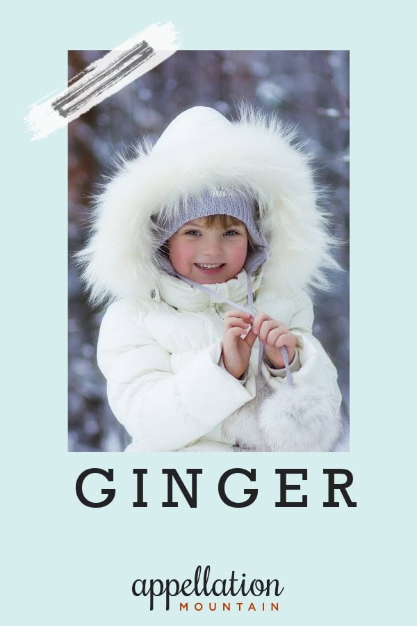 girl child wearing white coat with fur-trimmed hood standing outdoors; baby name Ginger