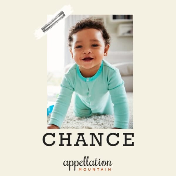 boy baby with dark curls wearing green onesie; baby name Chance