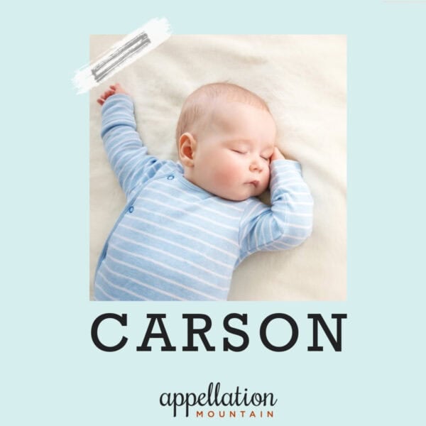 baby boy sleeping with arms outstretched wearing blue sleeper; baby name Carson
