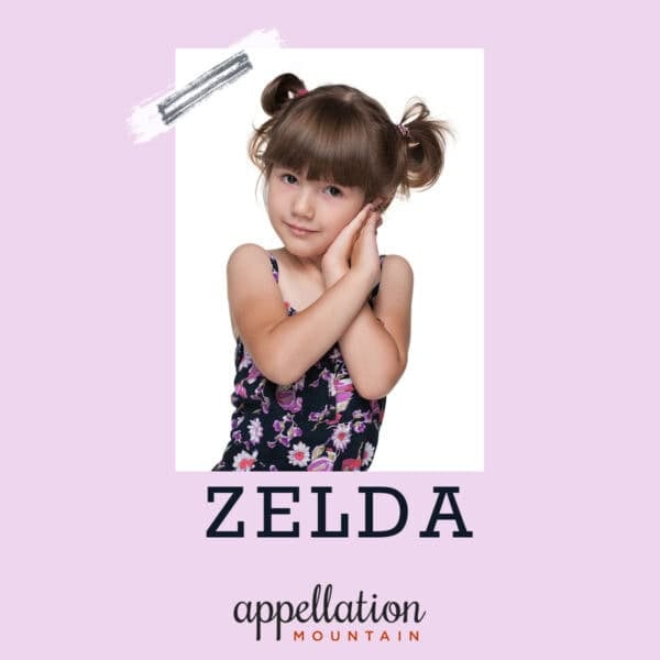 girl child with light brown hair in two buns wearing a floral print dark romper; baby name Zelda