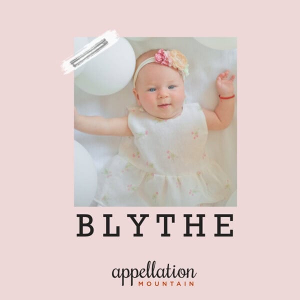 happy baby girl wearing white dress and headband with pink flowers on white background with white balloons; baby name Blythe
