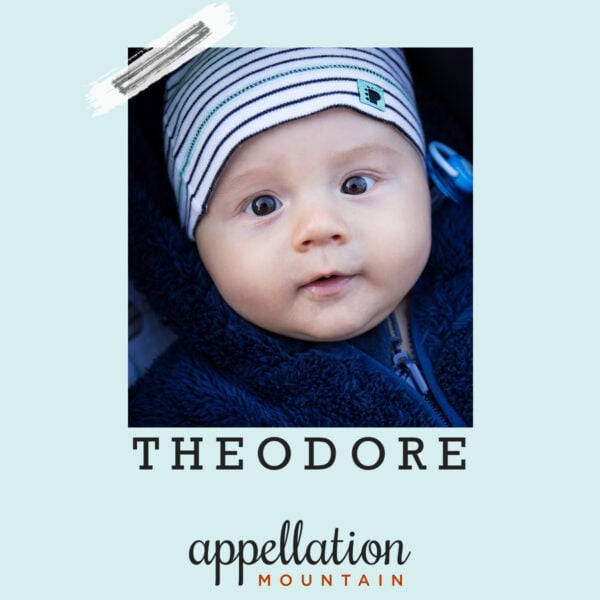 close up of baby boy's face wearing blue white striped hat; baby name Theodore