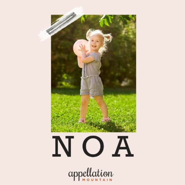 girl child with blonde hair holding a ball in a field; baby name Noa