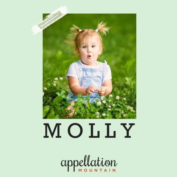 toddler girl with blonde pigtails and surprising expression wearing denim overalls sitting in field of green; baby name Molly