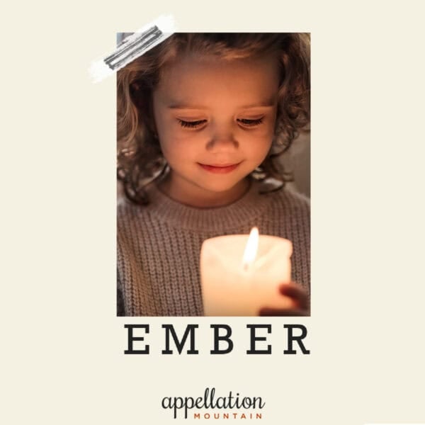 blonde girl child holding lit candle; baby name Ember