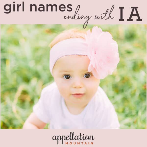 baby girl wearing oversized light pink floral headband on background of grass; girl names ending in IA