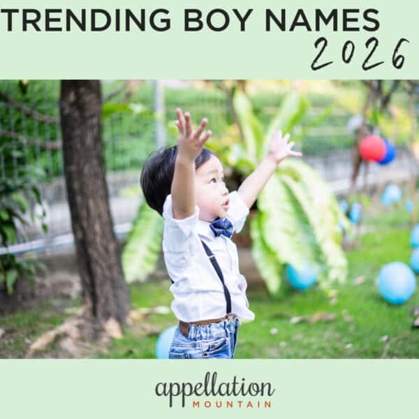 toddler boy of Asian descent wearing white shirt, jeans, and suspenders with arms raised up outdoors with balloons around; future Top 1000 boy names