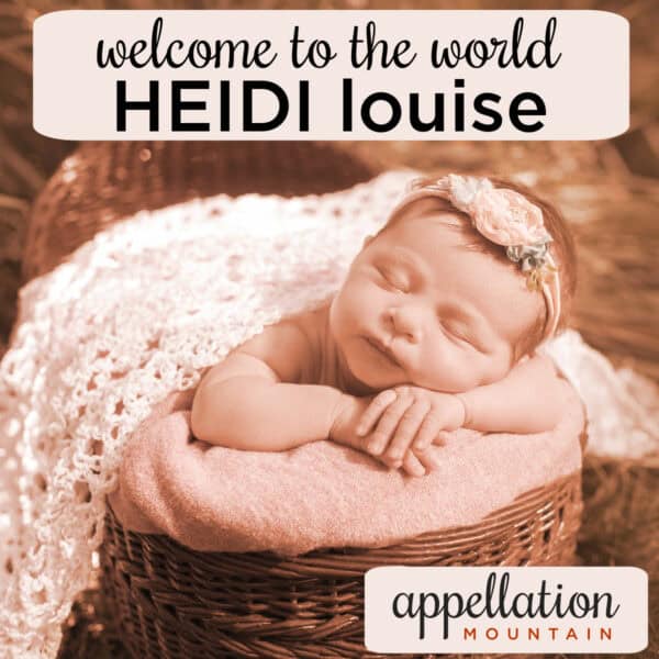 newborn baby girl sleeping in basket with headband on, covered in blanket "welcome Heidi Louise"