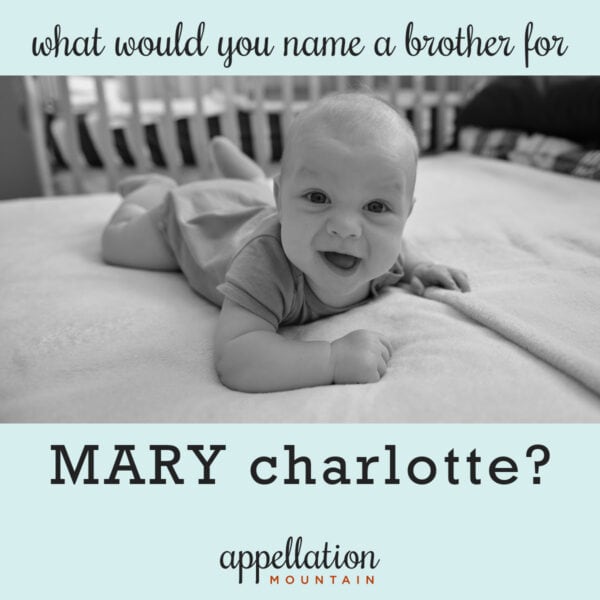 baby boy on stomach in crib, lifting up head and smiling "name a brother for Mary Charlotte"