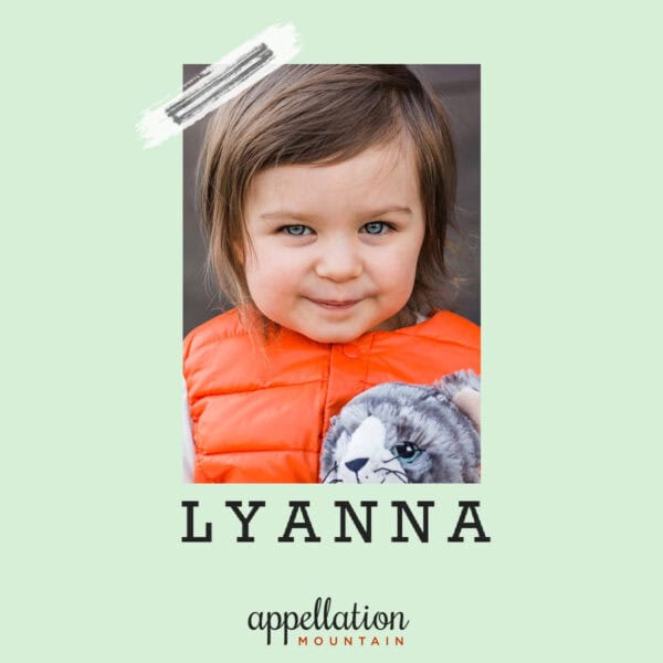 young girl with brown hair in an orange puffer vest holding a stuffed cat; baby name Lyanna