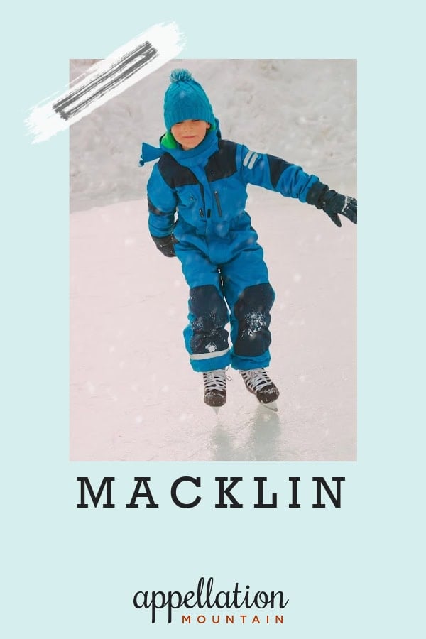 boy wearing blue jacket, hat, and snow pants plus hockey skates skating outside on snowy day; baby name Macklin