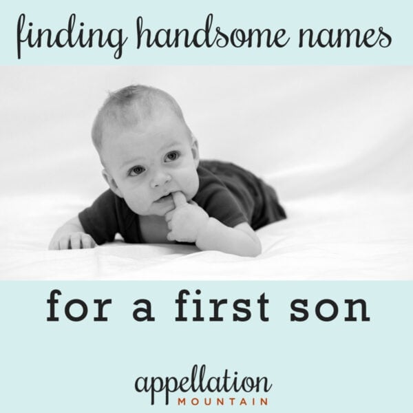 baby boy wearing dark onesie propped up on stomach with finger in his mouth; handsome boy names