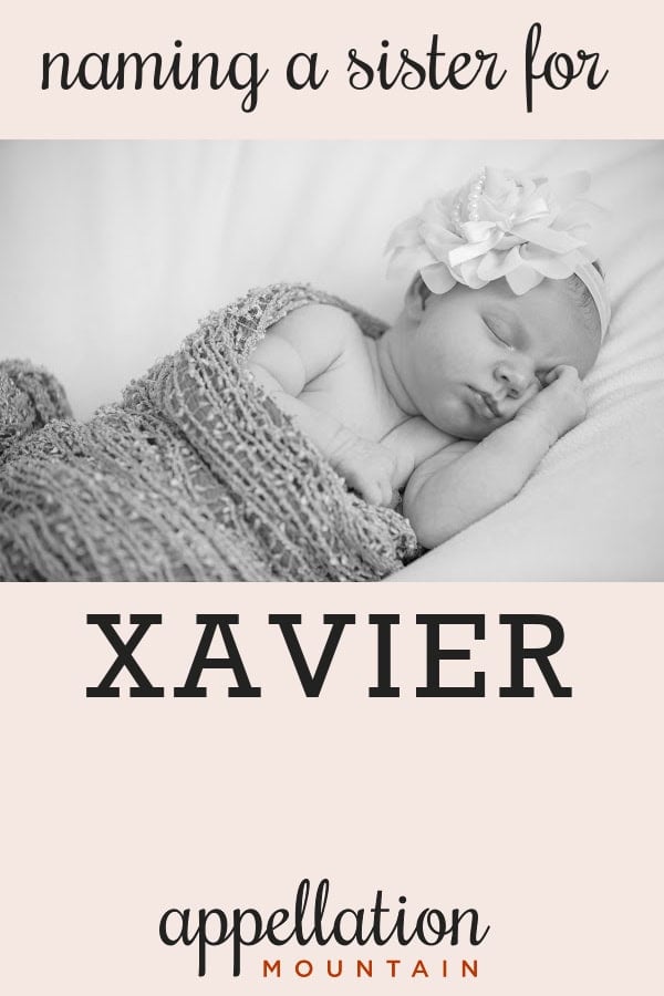 sleeping baby girl with floral headband wrapped in blanket; naming Xavier's sister