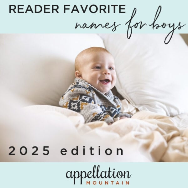 top boy names 2025; baby boy in sweater sitting on white chair with blanket