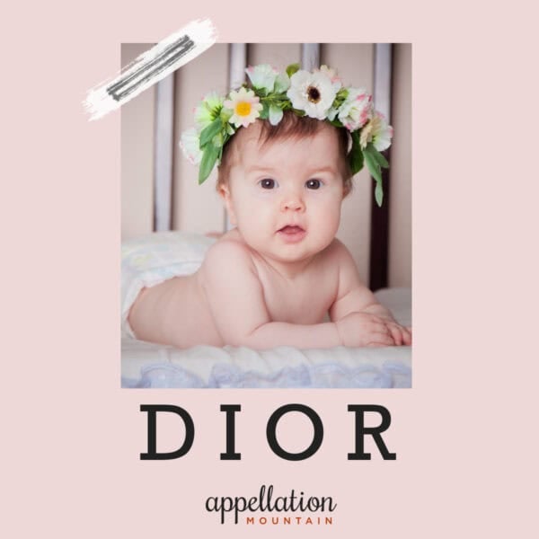 baby girl propped up on arms wearing wreath of flowers; baby name Dior