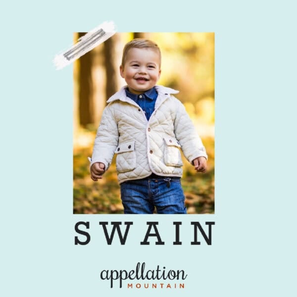 boy with short blonde hair wearing beige jacket and jeans in woods with golden leaves; baby name Swain