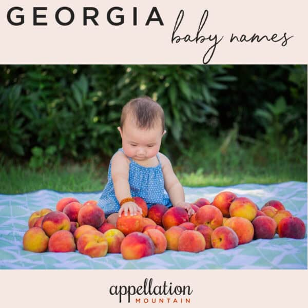 baby wearing blue sundress sitting on blanket surrounded by peaches; Georgia baby names
