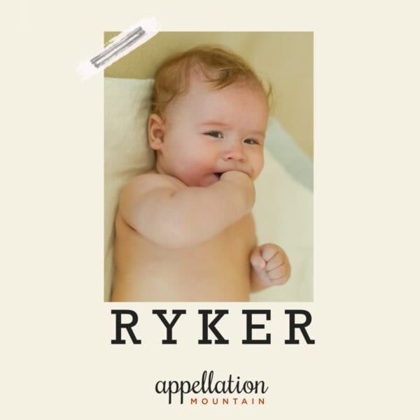 baby boy with blonde hair with fingers in mouth resting on off-white blanket; baby name Ryker