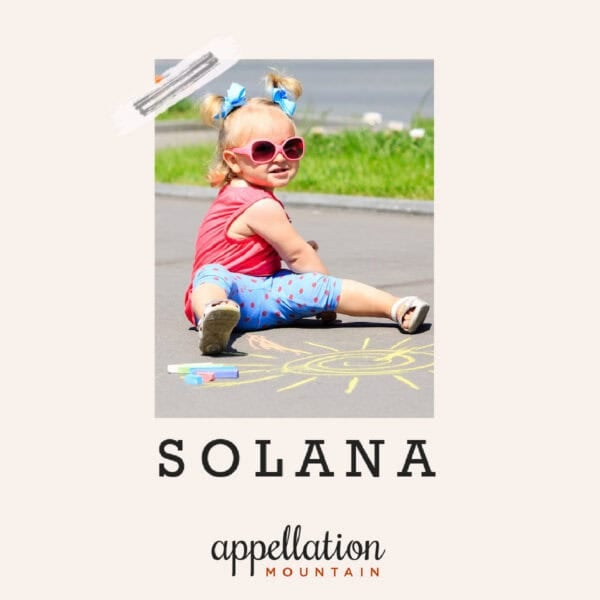 toddler girl with blonde ponytails wearing pink sunglasses, sitting on sidewalk in front of chalk drawing of a sun; baby name Solana