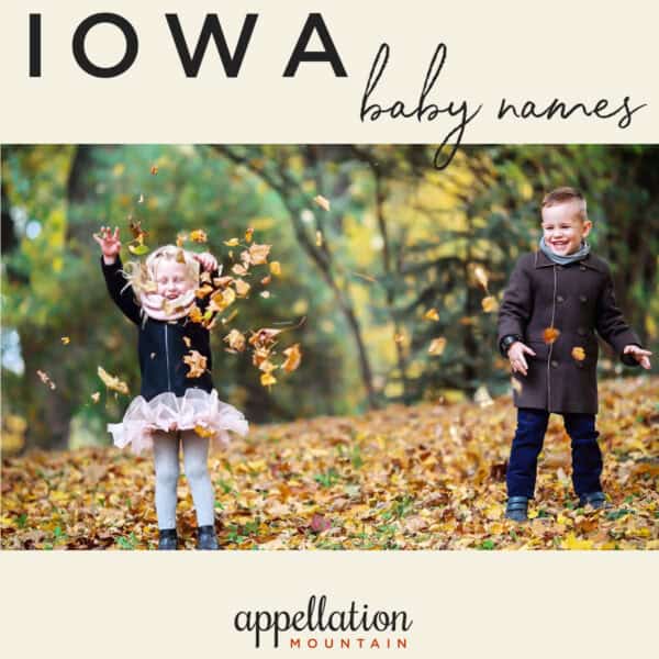 two children tossing oak leaves in the air standing in autumn woods; Iowa baby names