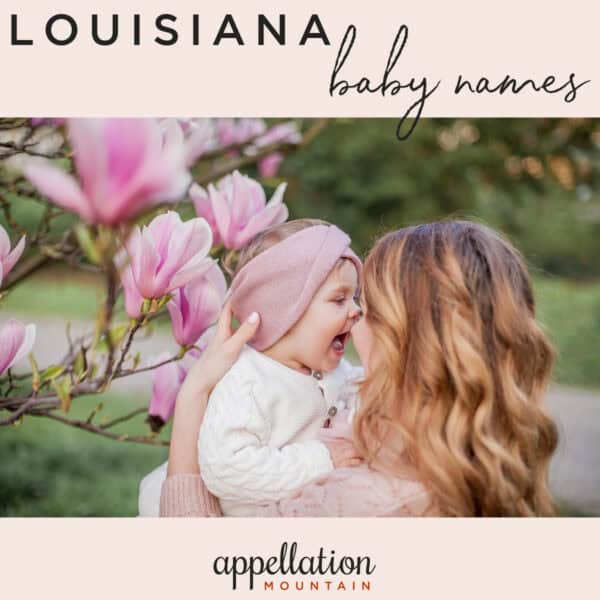 mom with long wavy light brown hair holding baby daughter wearing pink headwrap in front of a magnolia tree; Louisiana baby names