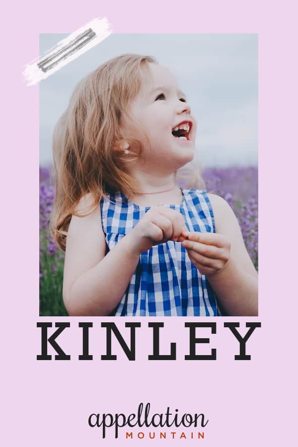 blonde girl in blue checked sundress standing in field of lavender; baby name Kinley