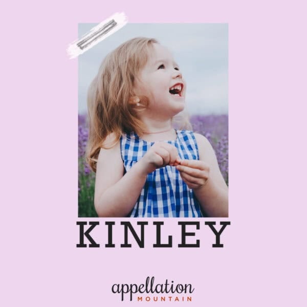 blonde girl in blue checked sundress standing in field of lavender; baby name Kinley