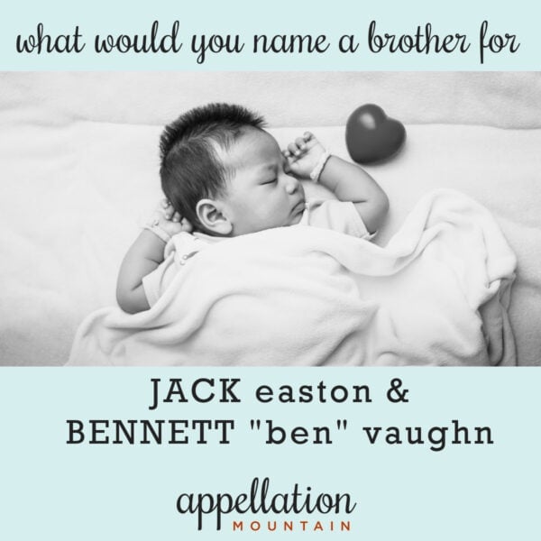 sleeping baby boy with arms out wearing white onesie with toy heart by his side; brother for Jack and Ben